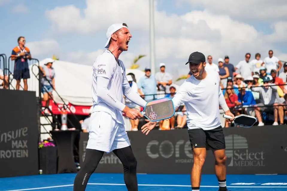 Andrei Daescu (L) celebrates a crushed winner with partner Johns (R) on their way to victory.